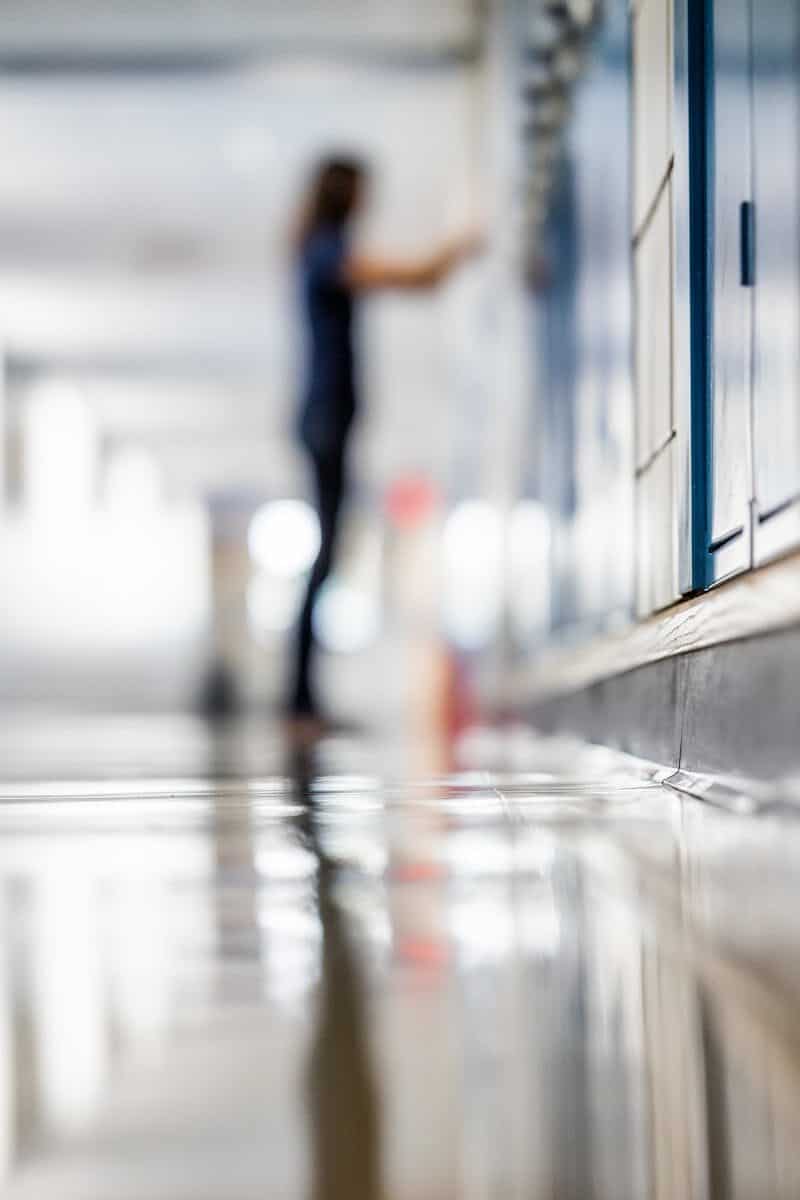 Abstract view of a school hallway with motion blur of a student by lockers.